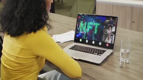 Biracial-businesswoman-using-laptop-for-video-call-with-diverse-business-colleagues