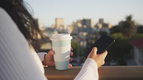 mixed race woman using smartphone on the street