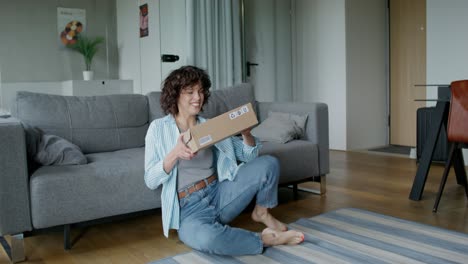 woman excitedly unboxing a package at home