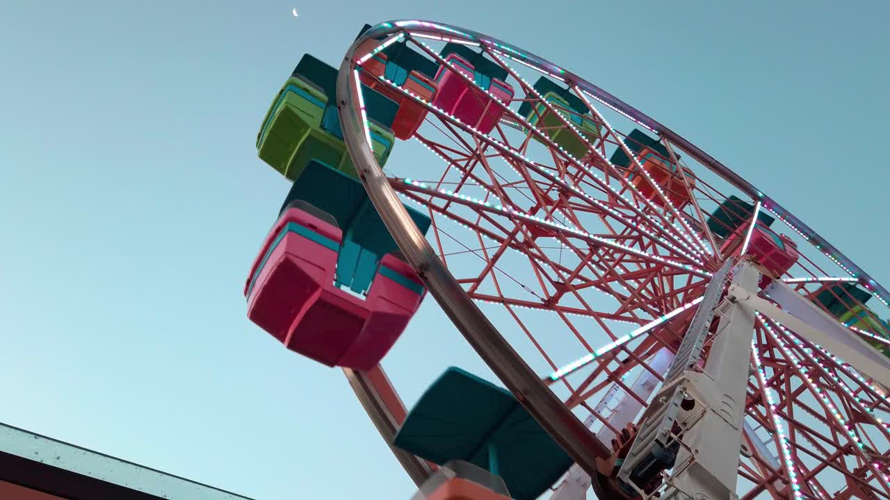 Wide shot of Virgin Wheel Boneless plaza during the day with moon in the sky, outdoor, static shot