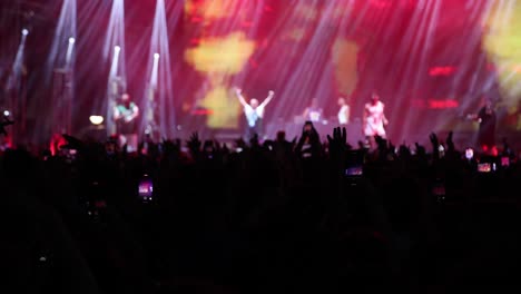 Fans-cheer-on-their-favorite-band-in-a-live-concert-with-the-stage-illuminated-by-neon-lights