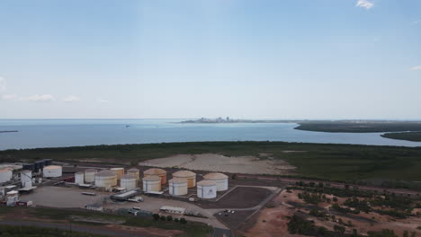 Slow-moving-drone-shot-of-East-Arm-Industrial-Area-and-Oil-Storage-Moving-Towards-Darwin-Skyline-and-City,-Northern-Territory