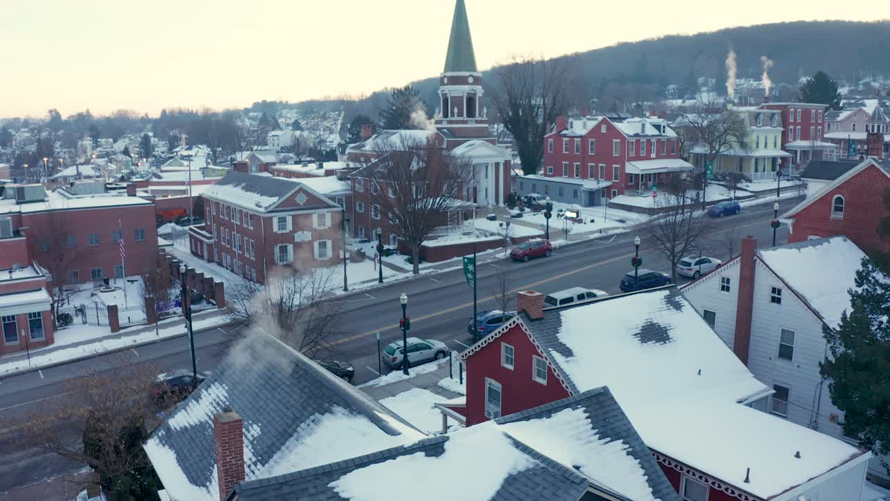 공중으로 기울이면 겨울 눈으로 덮인 작은 마을 공동체의 집과 교회가 드러납니다.