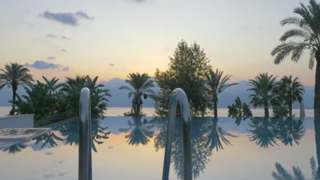 Outdoor-swimming-pool-on-resort-Scene-with-nature-background-at-sunset