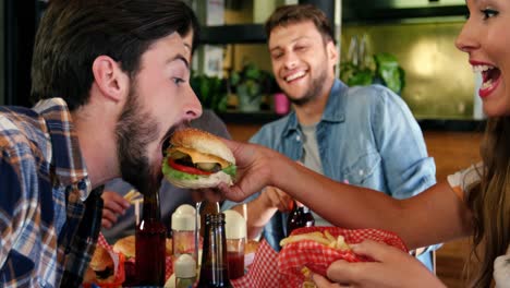 donna che dà da mangiare un hamburger a un uomo