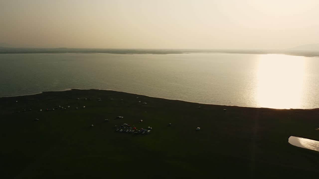 Aerial view shot of Landscape at the end of Pa Sak Jolasid Dam with green grass and water