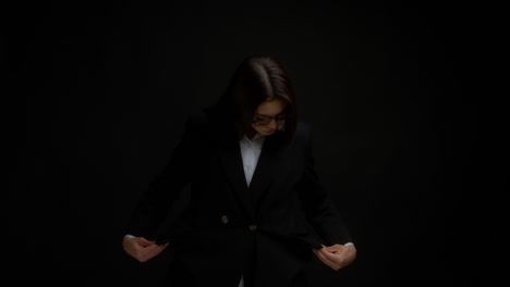 mujer de negocios con gafas que muestran bolsillos vacíos en una chaqueta