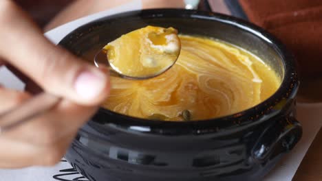 close up of a bowl of pumpkin soup with a spoon