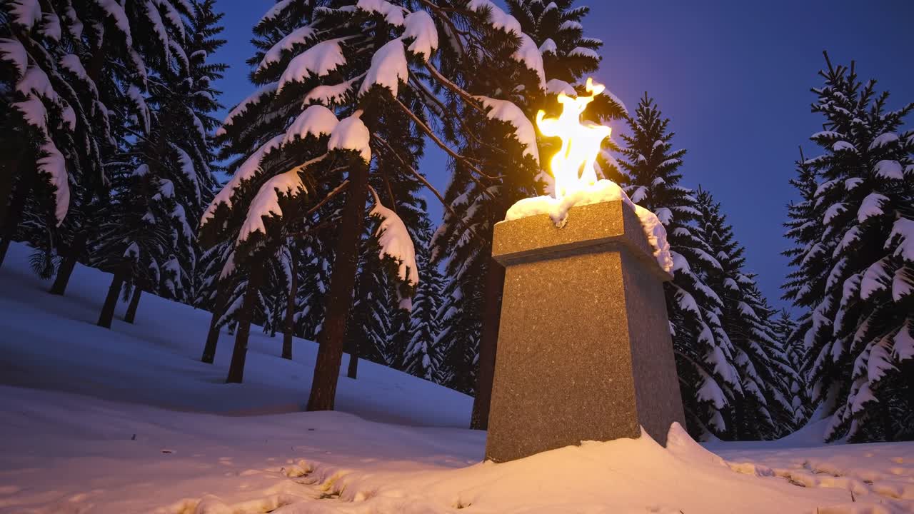 Illuminated Monument in Snowy Forest at Twilight