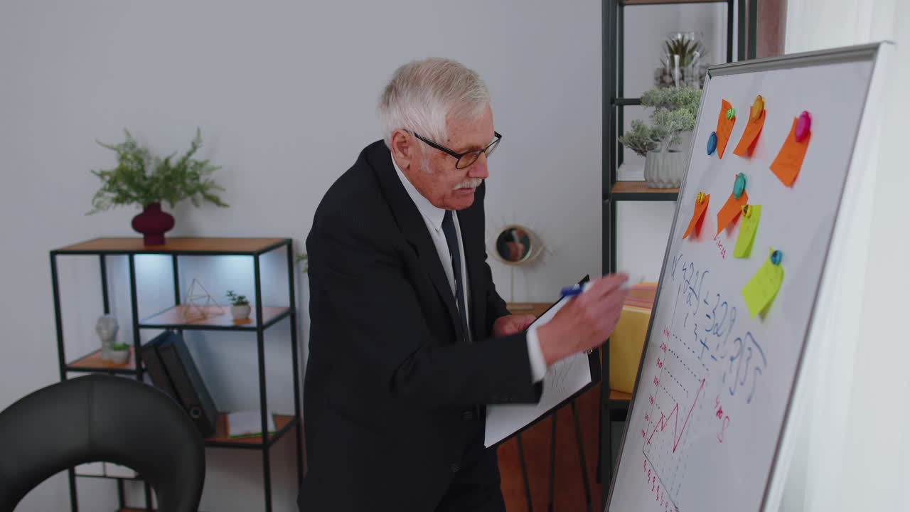 hombre de negocios senior entrenador líder de la conferencia orador explicar la estrategia del proyecto en la tabla blanca de la oficina