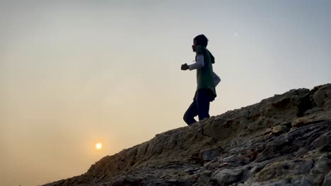 Side-wide-view-of-man-running-in-place-outdoor-at-sunset,-slow-motion,-static