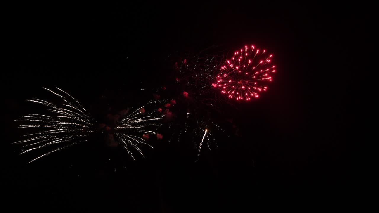 largo tiempo bucle sin fisuras de verdadero abstracto colorido espectáculo de fuegos artificiales festival en el cielo de fondo negro durante el día festivo nacional, fiesta de año nuevo 2022