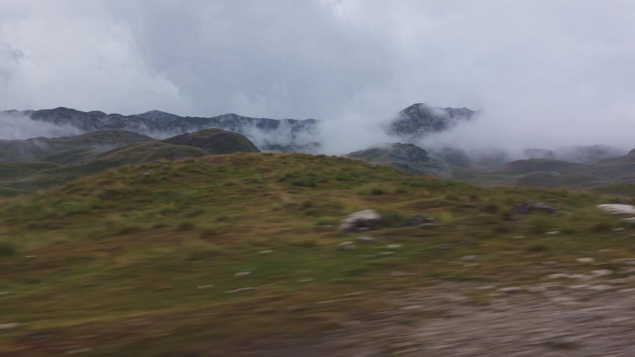 Vista panoramica di dolci colline verdi nebbiose e montagne coperte di nebbia nel Parco Nazionale di Durmitor, Montenegro