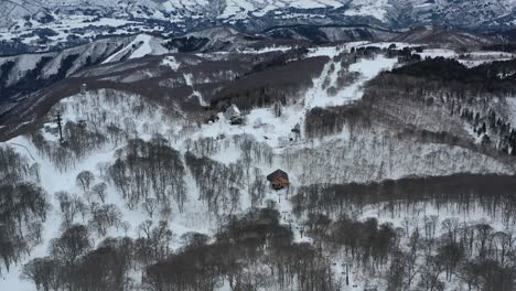 pequeña cabaña en las colinas de la montaña durante el invierno cubierta de nieve en nozawa onsen japón, antena