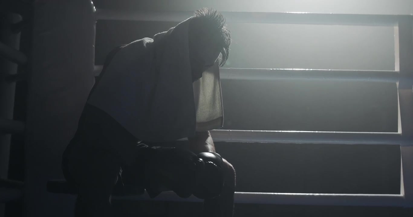 Dramatic Silhouette of a Boxer Resting in a Dark Ring