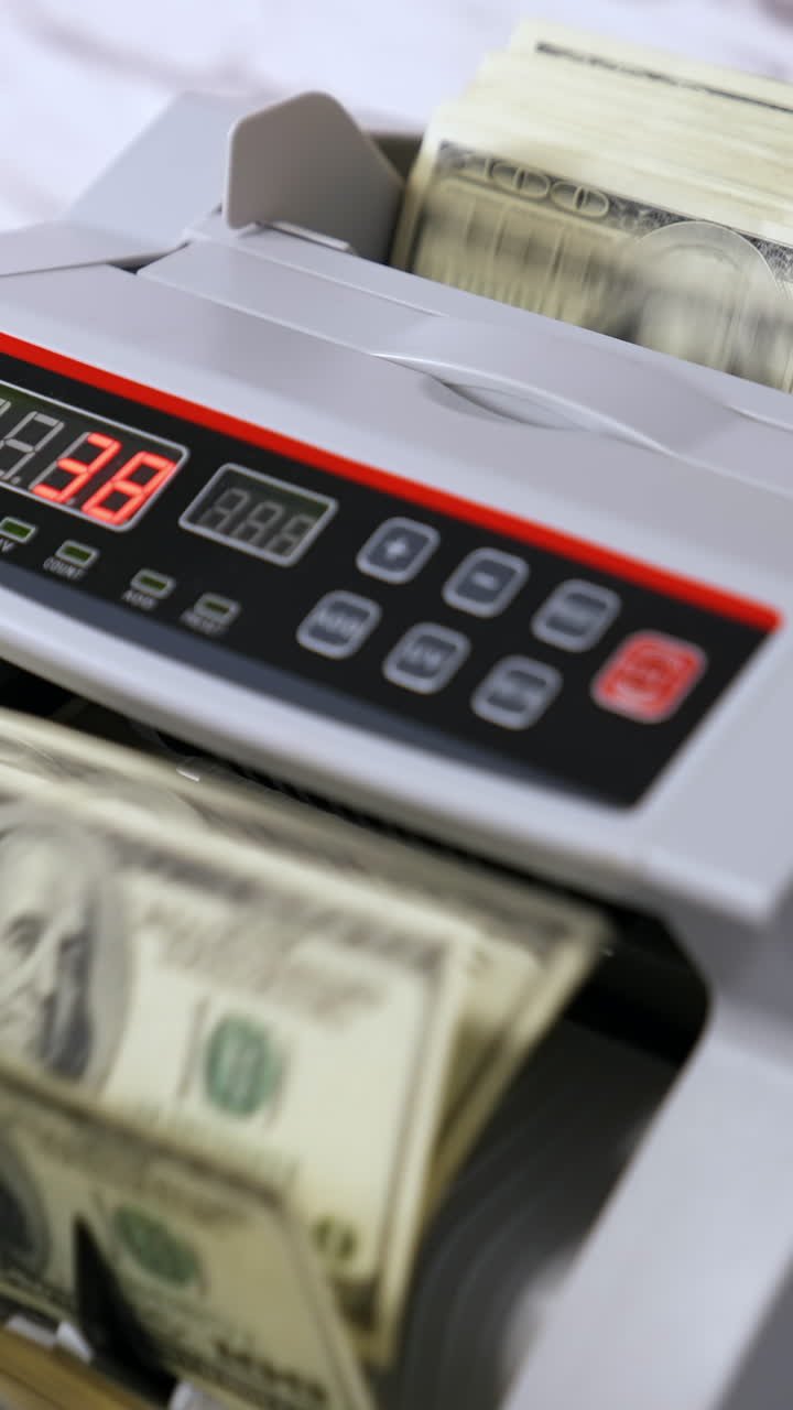Counting dollar banknotes. Money counting equipment for paper money calculation Vertical video