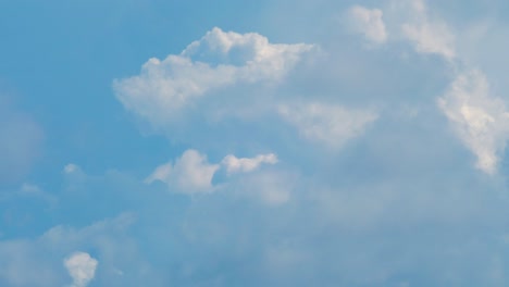 Time-lapse-of-beautiful-white-fast-moving-puffy-cumulus-clouds-in-sunny-summer-day,-medium-shot