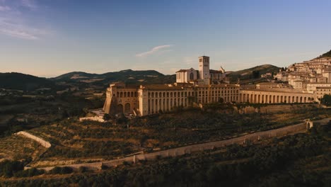 aerial orbit around the convent of saint francis of assisi in italy during a summer sunset