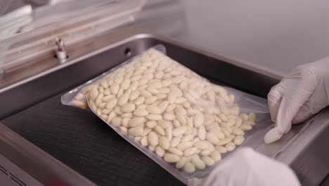 food production and packaging, putting a plastic bag full of blanched almonds in a vacuum packing machine