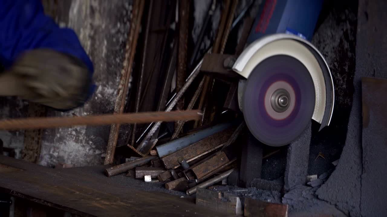 el trabajador corta algunos tubos metálicos con un molinillo