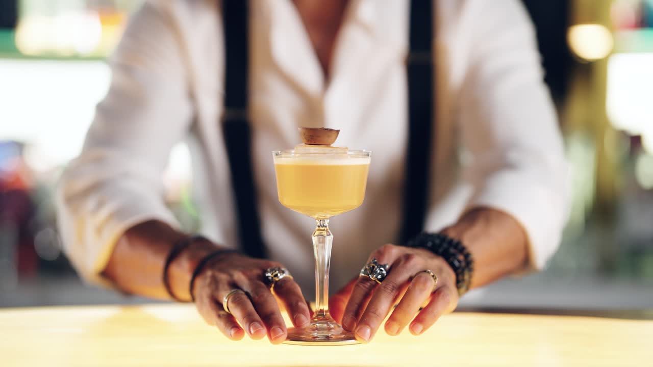 Bartender's Hands Place a Craft Cocktail on a Glowing Bar