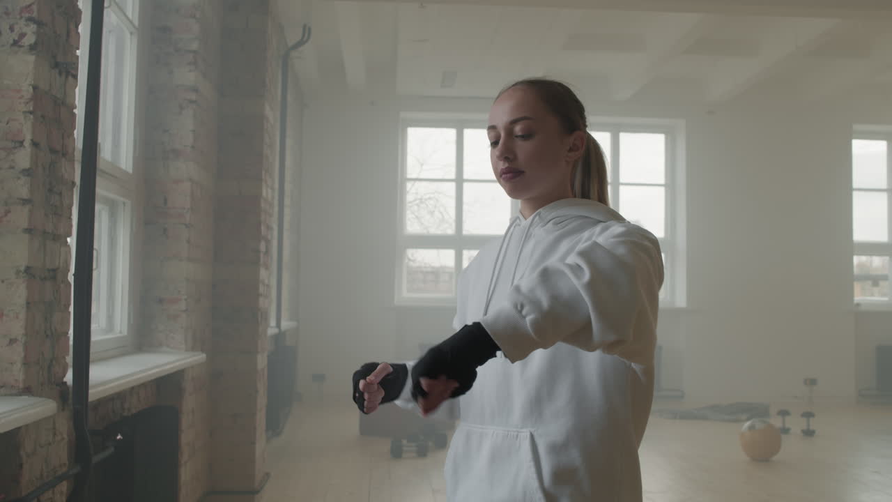 Female Boxer Bandaging Hands With Wraps