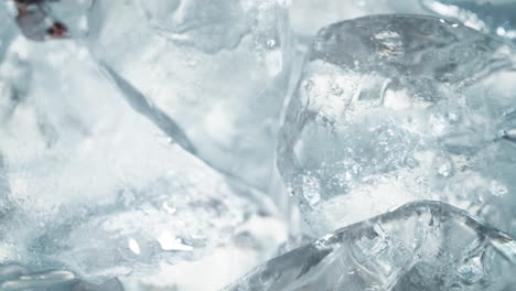 stream of pure water flooding ice cubes, making a wave in macro and slow motion