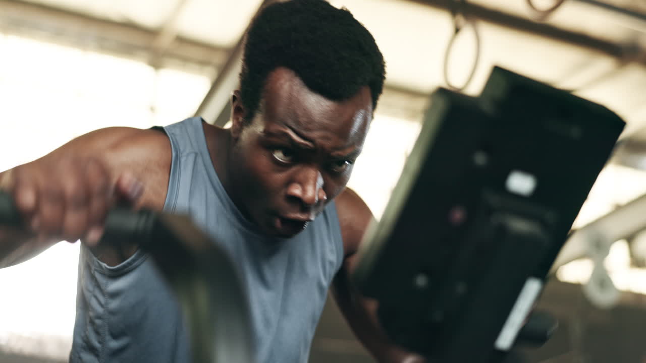 Black man, fitness and cycling at gym in cardio