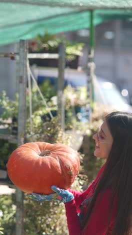 mujer sosteniendo una gran calabaza