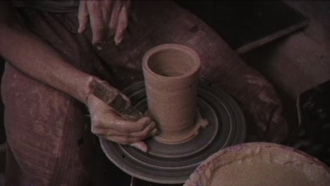 the potter makes a jug of clay. vintage effect. a man makes a vase on a potter's wheel