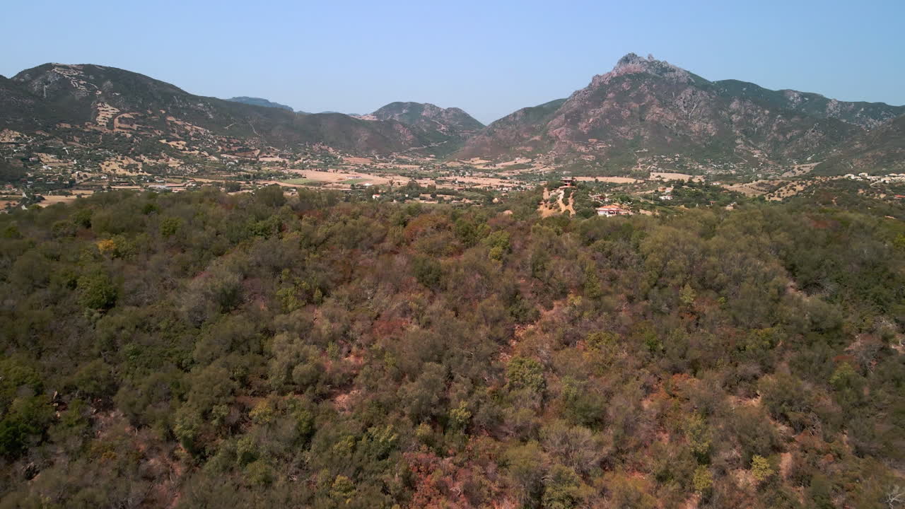 campo de campo en un valle visto más allá de las montañas bajo un cielo azul en un día soleado en cerdeña, italia
