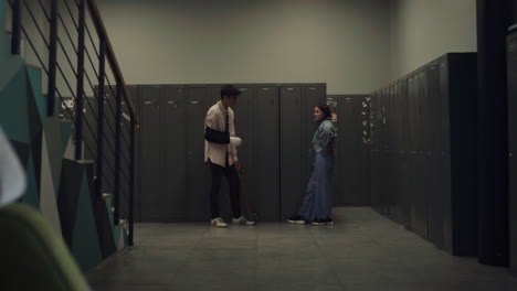 Two-students-standing-talking-after-classes.-Couple-teens-chatting-near-lockers.