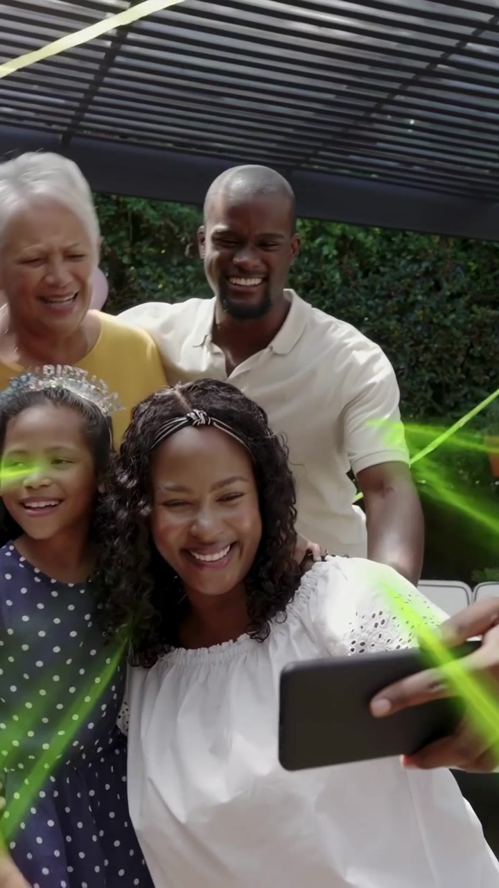 Vertical video: Mom tapping phone for selfie, moving for group while green sparks popping at party
