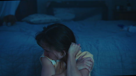a traumatised and disoriented girl sits on the bedroom floor