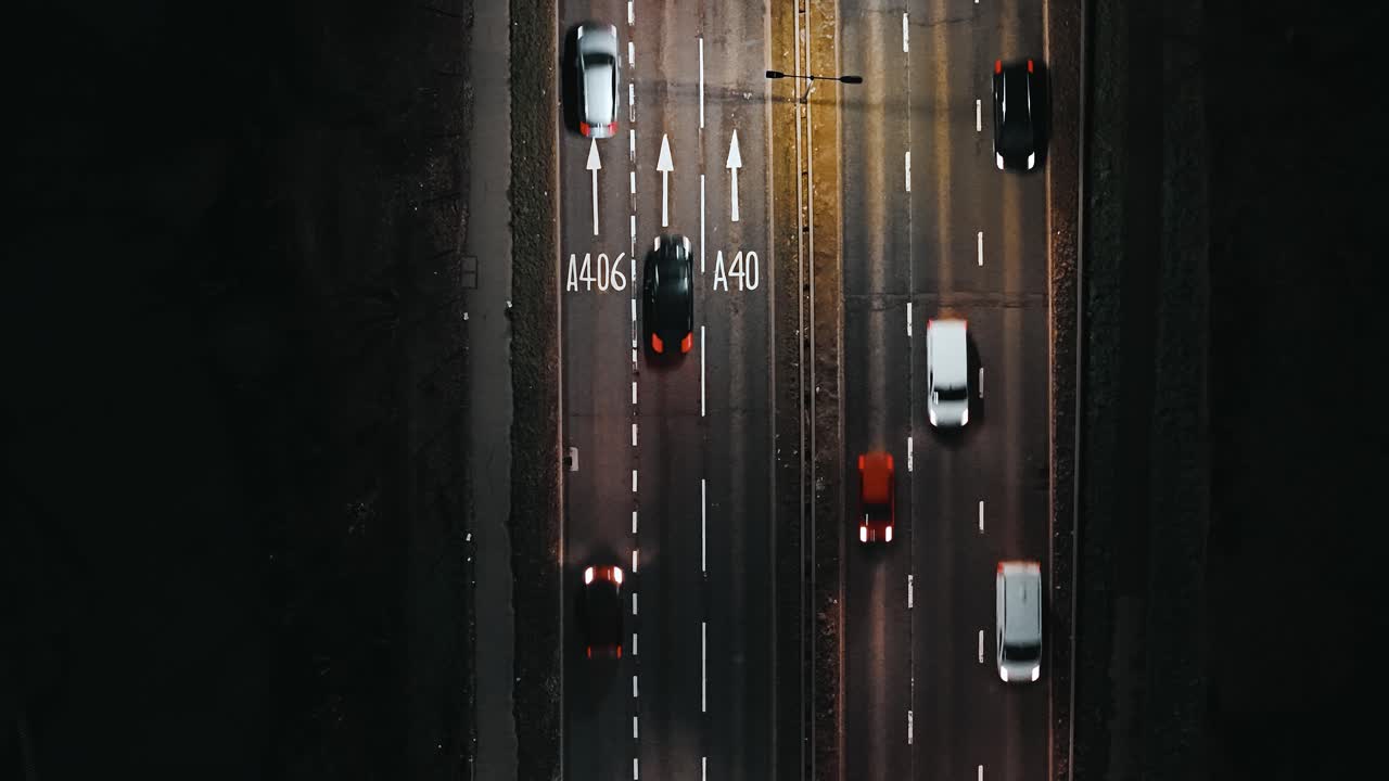 Evening commuter traffic on London A40 road, aerial top-down shot at night
