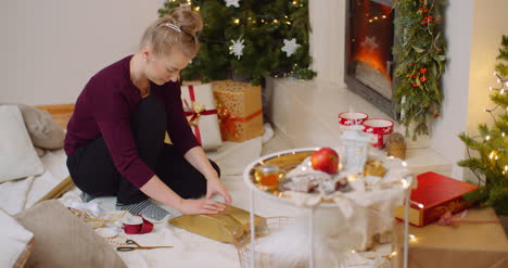 Frau-Wickelt-Weihnachtsgeschenk-Am-Kamin-Zu-Hause-Ein-6