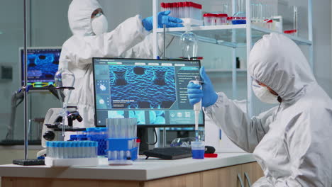 scientist in protection suit using micropipette filling test tubes