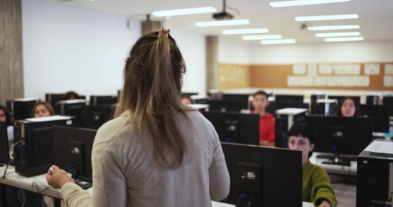 Insegnante che conduce una lezione di informatica con studenti in classe