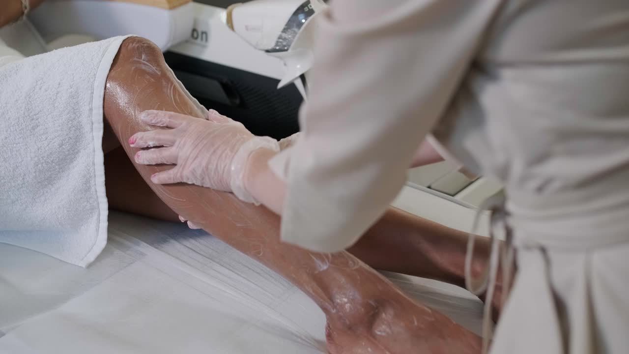 Epilazione laser e cosmetologia nel salone di bellezza. Procedura di depilazione Epilazione laser, cosmetologia, spa e concetto di epilazione. Bella donna che ottiene rimozione dei capelli sulle gambe