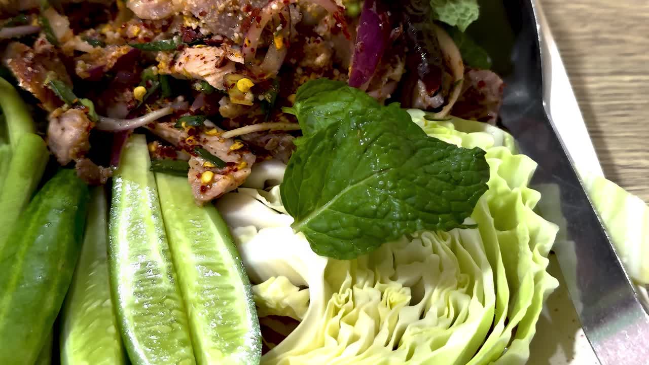 A colorful arrangement of fresh cabbage, cucumbers, and mint leaves, showcasing a delightful salad presentation.