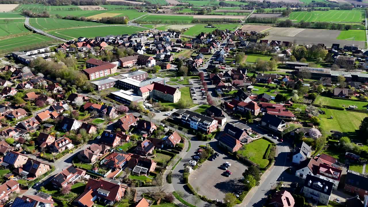 Housing area with single Family houses and solar panels on roof. Historic homes and houses in USA. Aerial forward wide shot. Sunny spring day in rural town. Countryside farm fields in distance.