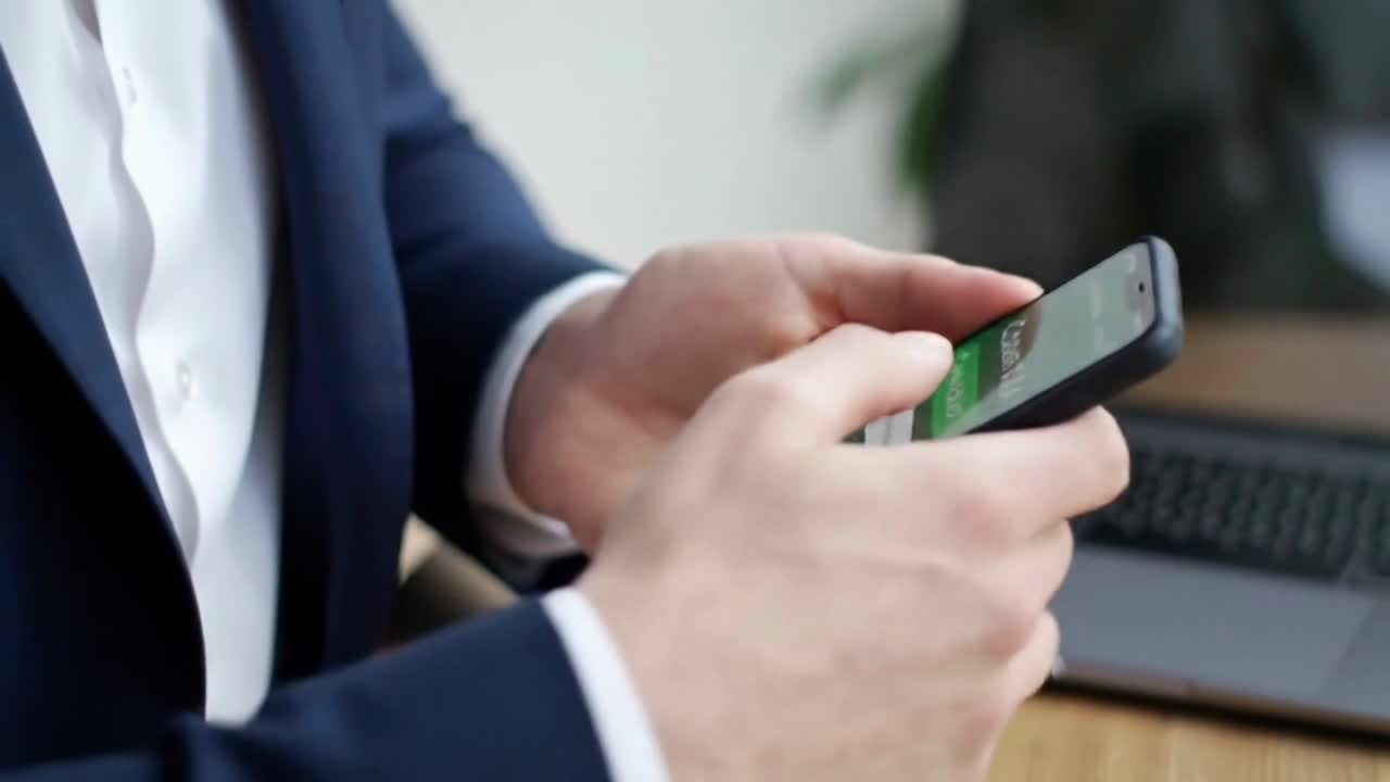 Close-Up of a Businessman's Hands Scrolling on a Modern Smartphone