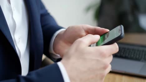 close-up of a businessman's hands scrolling on a modern smartphone