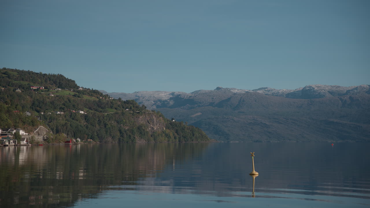 Scenic landscape shot of the mountainside hitting the water and the fjord on a sunny day