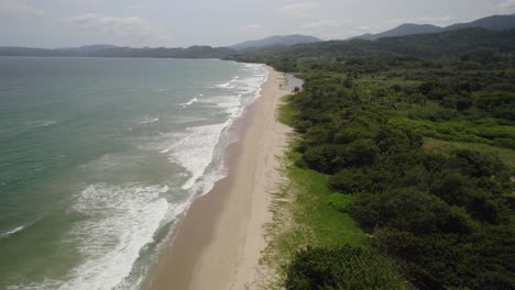 a tranquil tropical coast with calm waves along la guaira beach, aerial view