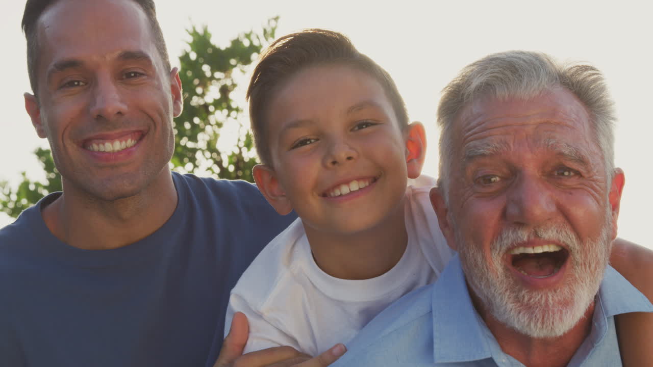 Portrait Of Male Multi-Generation Hispanic Family Relaxing In Garden At Home Together