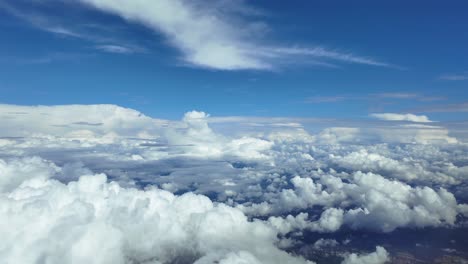 an immersive flight experience in a supersonic flight viewed from a jet cockpit, flying over cottony white cumulonimbus clouds, with storm clouds ahead, under a blue sky. 4k