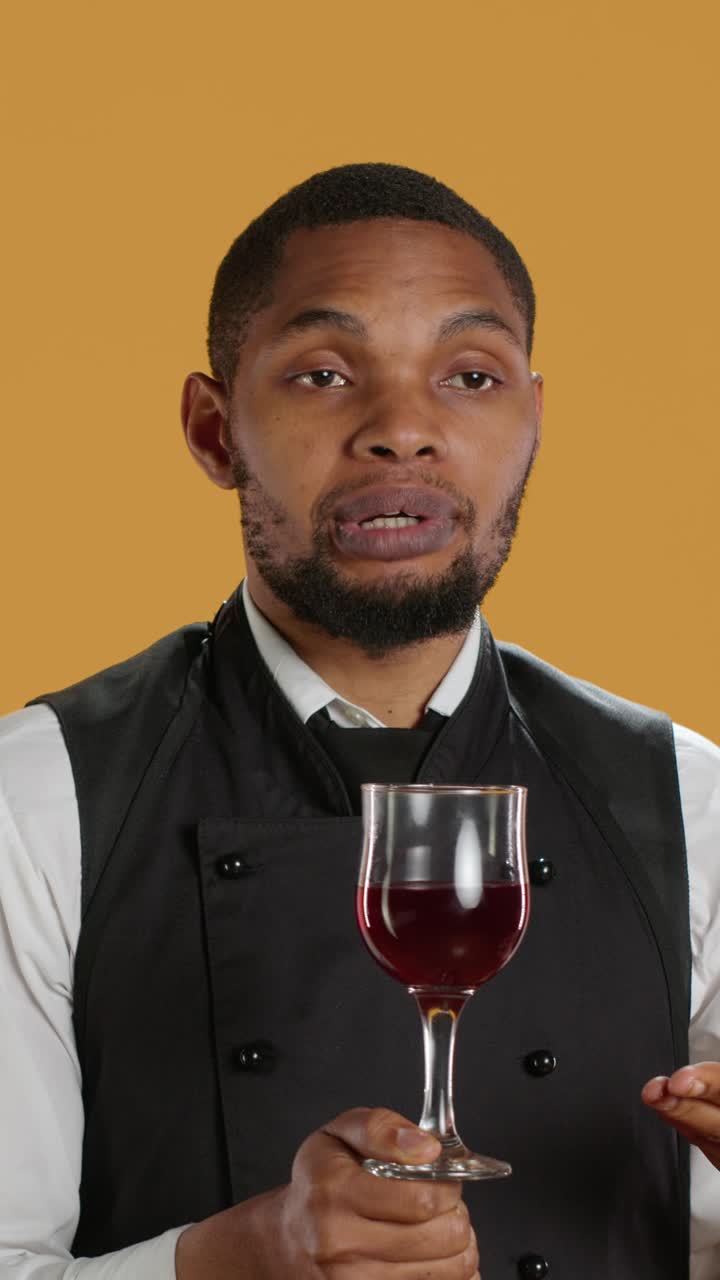 Professionelle/r Sommelier erklärt Rotwein in einem Glas