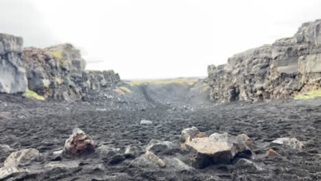 Male-holding-a-handful-of-black-volcanic-sand-in-Iceland