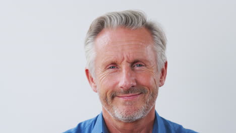 Studio-Shot-Of-Senior-Man-Against-White-Background-Laughing-At-Camera